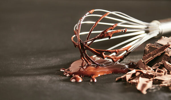A whisk covered in chocolate