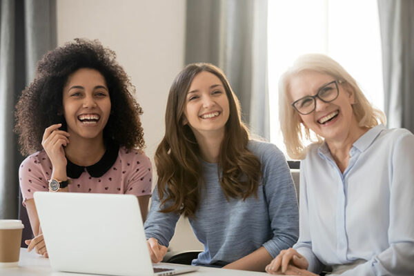 Three women looking at a laptop