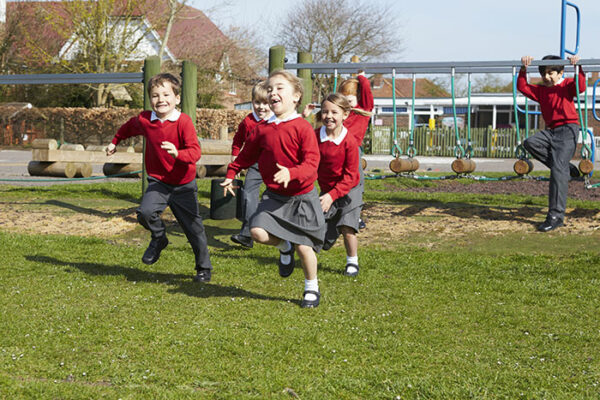 Group of young children playing in school uniform