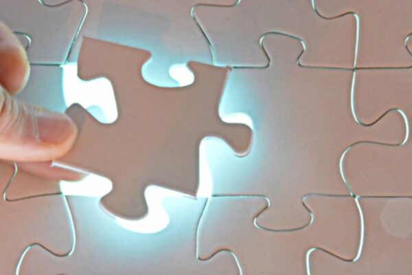 someone placing the last piece in all-white jigsaw