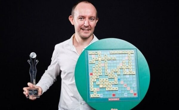 Scrabble champion with trophy and winning board