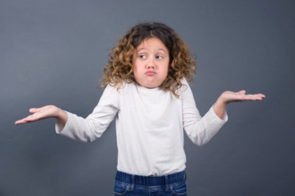 a little girl shrugging her shoulders with arms indicating 'I don't know'