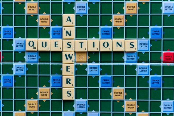scrabble board with words ANSWERS and QUESTIONS