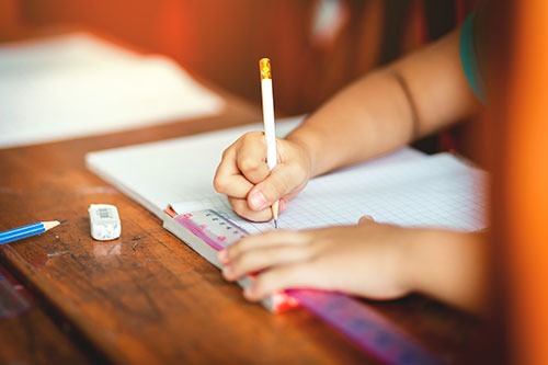 child doing homework at a desk