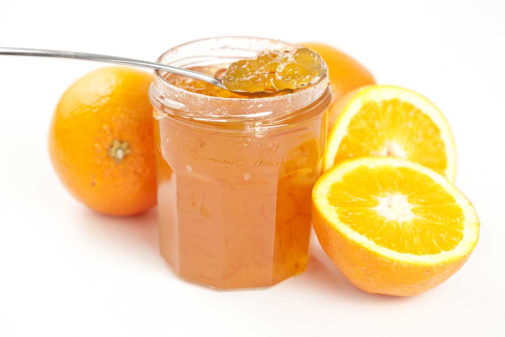 jar of marmalade with cut oranges